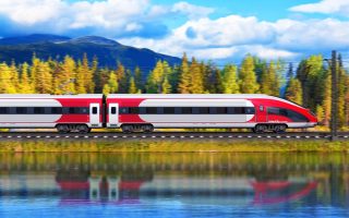Creative abstract railroad travel and railway tourism transportation industrial concept: scenic summer view of modern high speed passenger train on tracks with lake or sea and mountains in background with motion blur effect